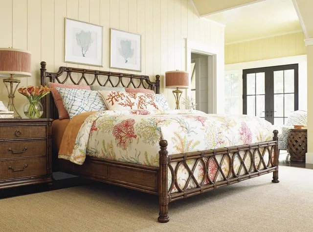 A timber bed with open decorative details sits beside matching warm storage and pale walls.