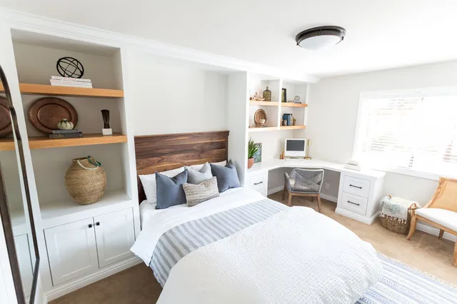 A timber headboard sits between built-in shelves and pale lower cupboards.