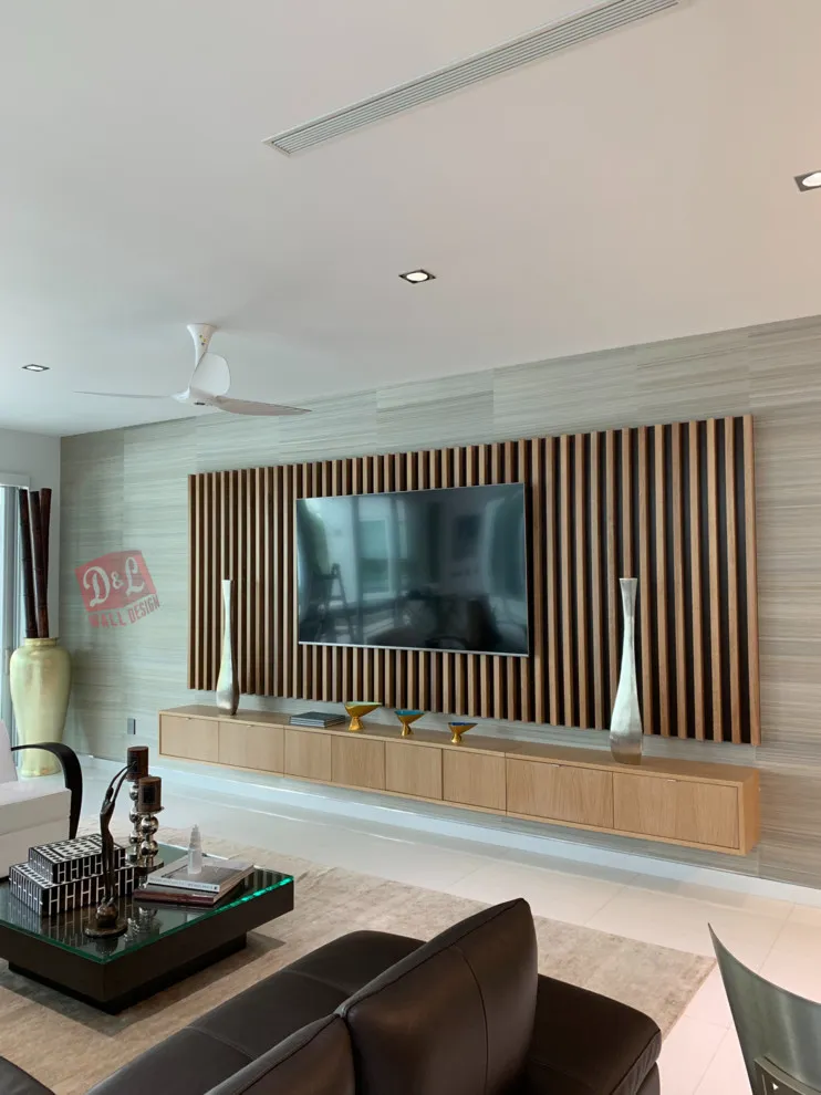 Vertical timber slats form a panel behind a television above a floating cabinet