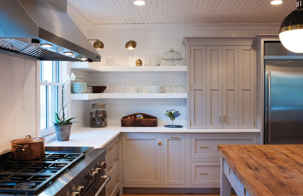 Pale taupe cabinets meet a wooden worktop and white open shelves in a compact kitchen