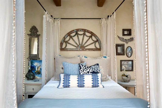 Arched timber wall feature above blue and pale bedding within a dark canopy frame