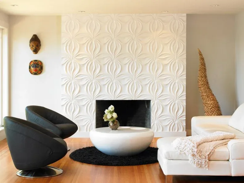 White raised patterned fireplace wall with black chairs, pale sofa and round white coffee table