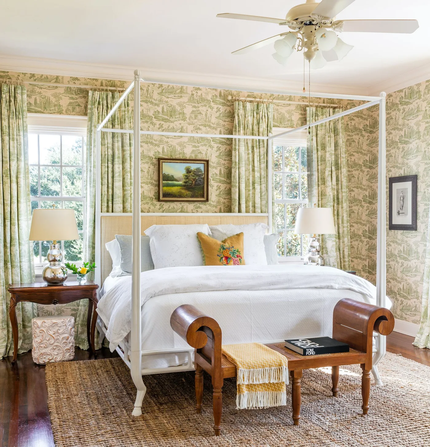 Green scenic wallpaper with matching curtains around a pale four-poster bed and white bedding.
