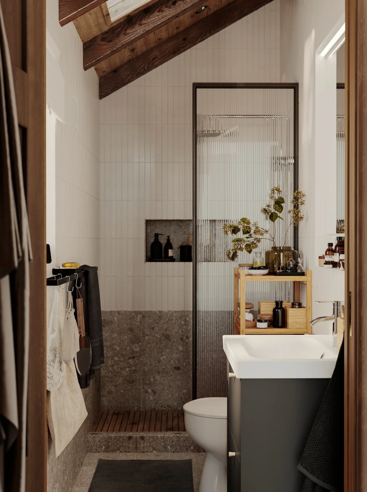 A narrow bathroom has white wall tiles, exposed wooden roof beams, a dark vanity, open wooden shelves and a slim textured glass shower screen