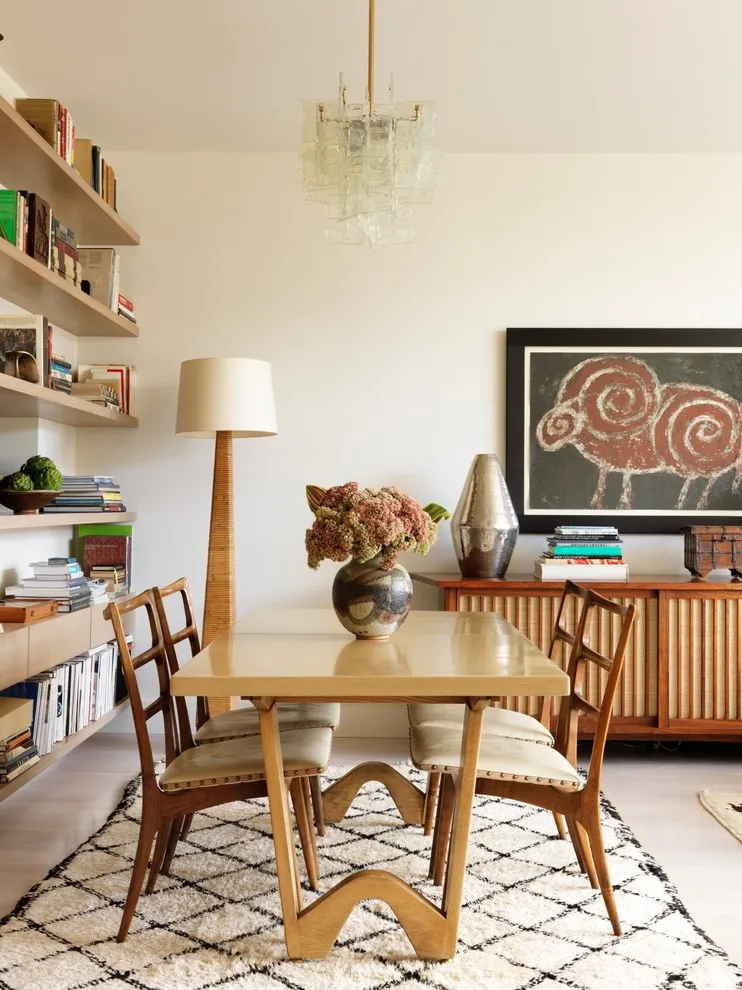 A small timber table sits beside open shelving and a patterned rug in an apartment