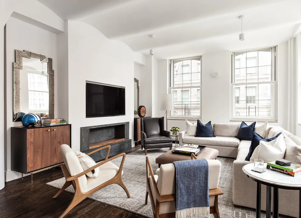 Timber-framed lounge chairs face light seating near tall windows