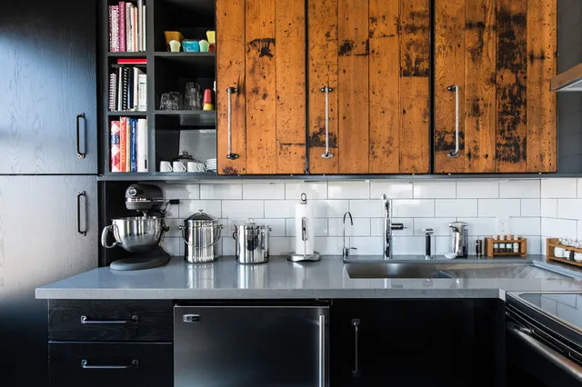 Dark base cabinets sit beneath strongly grained timber upper doors and open shelving.