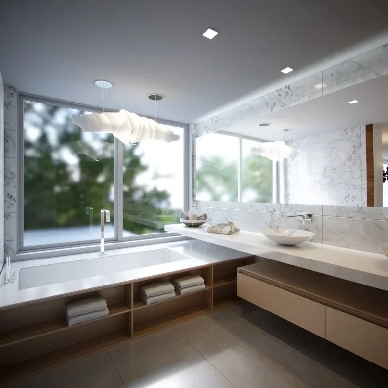 A rectangular built-in bath sits beneath garden-facing windows beside open wood towel shelves and a long pale counter with a white vessel basin